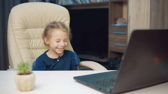 Portrait of a Little Girl Watching a Video on a Laptop