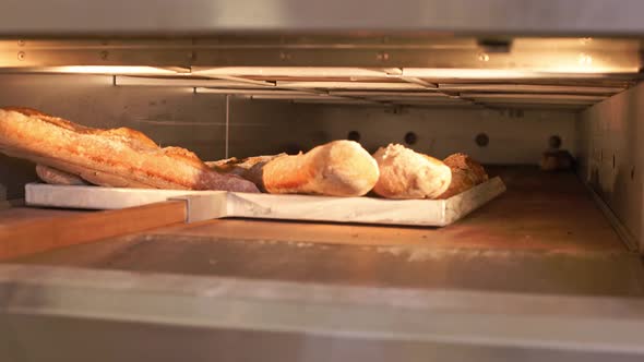 The Baker Shovels Bread From the Oven