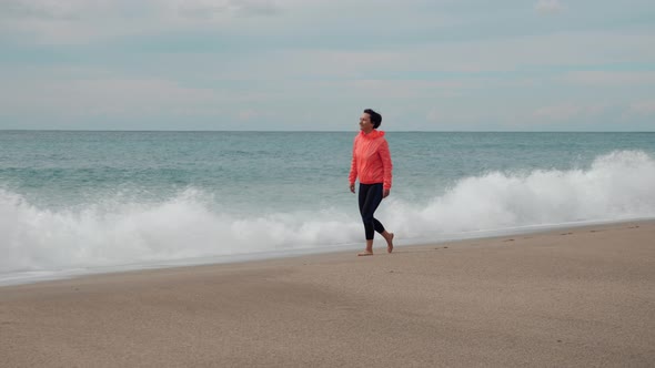 Woman walking on sady stormy beach