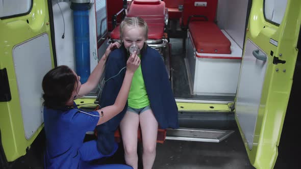 Girl Sit an Ambulance Car with Oxygen Mask.