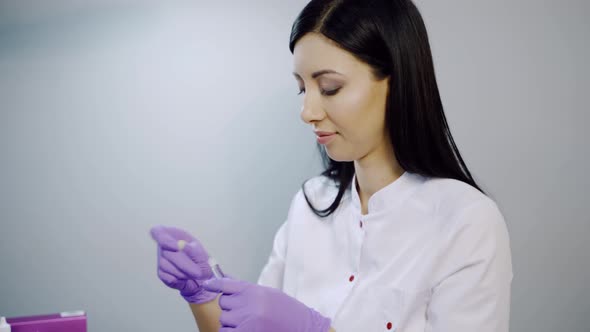 Cosmetologist Prepares a Syringe for Beauty Injections in the Salon