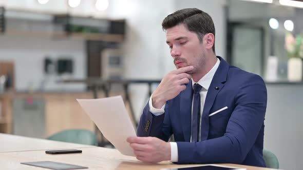 Focused Businessman Doing Paperwork in Office