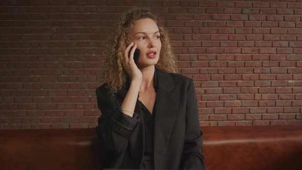 Handheld Shot of a Businesswoman Talking on Her Phone in a Suit