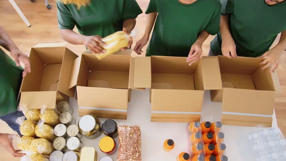 Happy Volunteers Packing Food in Donation Boxes