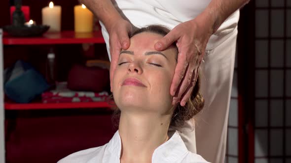 Happy Woman Enjoying Relaxing Head Massage at Thai Spa Center