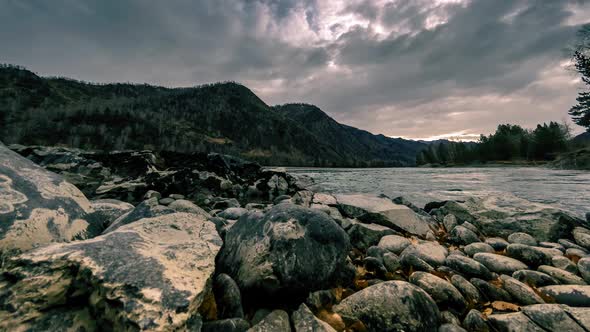 Time Lapse Shot of a River Near Mountain Forest. Huge Rocks and Fast Clouds Movenings. Horizontal