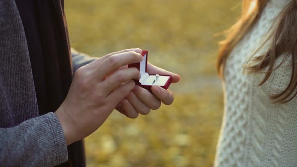 Guy Putting Beautiful Diamond Ring on Finger of His Bride, Serious Relationship