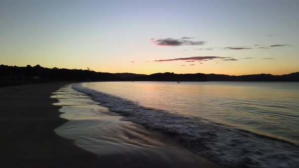 Floating across the small waves of Cooks beach at sunset