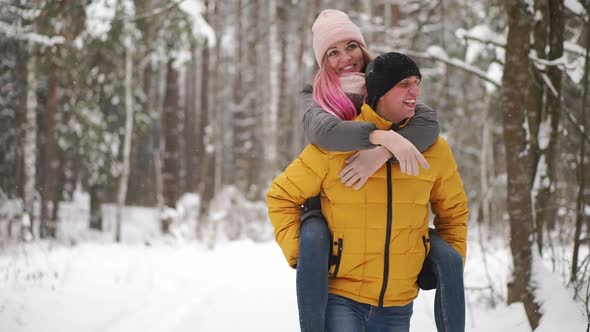 Happy Loving Couple Walking in Snowy Winter Forest, Spending Christmas Vacation Together. Outdoor