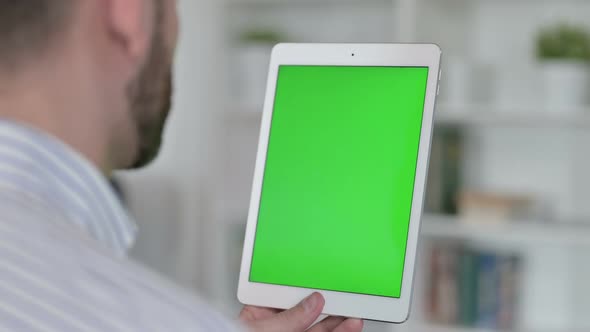 Rear View of Young Man Using Tablet with Chroma Screen