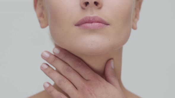 Studio portrait of young, beautiful and natural blond woman applying skin care cream. F