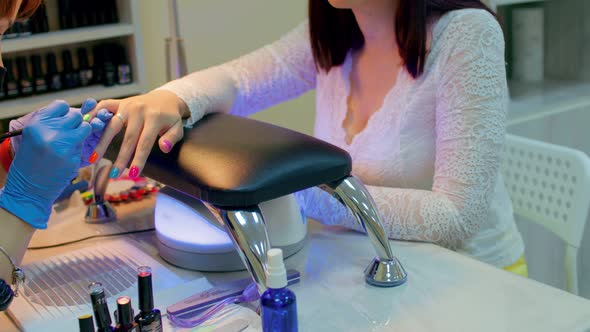 Master of Manicure Getting Professional Manicure in Beauty Salon Woman Puts Nail Polish