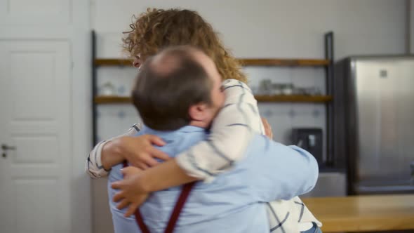 Excited Young Couple in Love at Home Embracing Celebrating Success