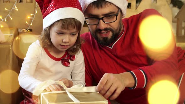 Father with Child Open Gift Box on Background of Christmas Tree