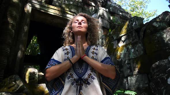 Young Yogi Woman In Meditation at Ancient Temple Ruins
