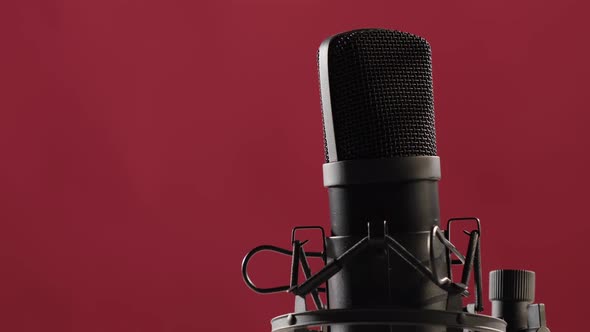 The Microphone is Spinning Against a Pink Background