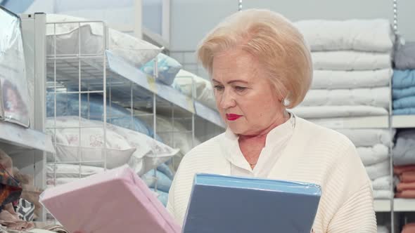 Charming Senior Lady Shopping for Bedding at Furniture Store