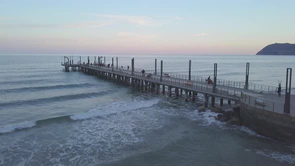 Alassio pier aerial view with people at sunset. Travel vacation tourism in Liguria, Mediterranean Se