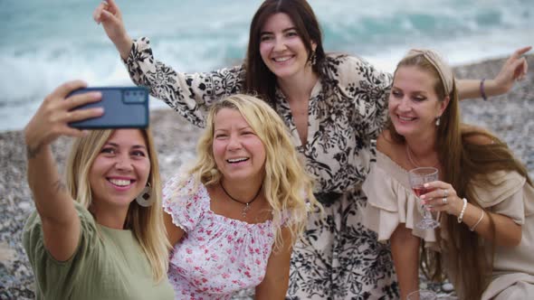 Four Happy Women Taking a Selfie on the Pebble Beach