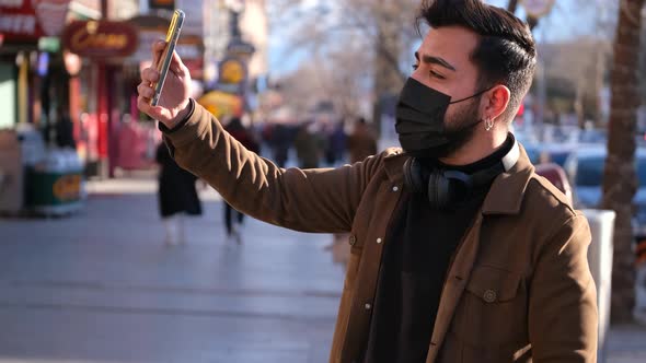 Man in Face Mask Taking Selfie