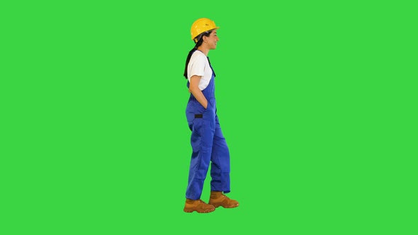 Young Woman in Yellow Hardhat Walking on a Green Screen Chroma Key