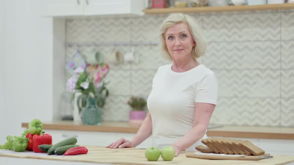 Healthy Senior Old Woman Looking at the Camera While Standing in Kitchen