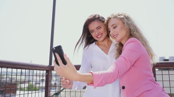 Women Making Photo On Mobile Phone Outdoors