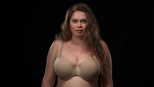 Portrait of Confident Overweight Caucasian Woman in Bra Looking at Camera with Seductive Facial