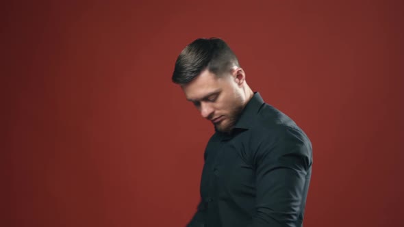 Elegant male model in studio. Confident businessman standing with his hands folded at his chest