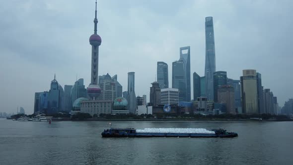 Shanghai Skyline and Boat Passes on the Huangpu River on a Cloudy Day