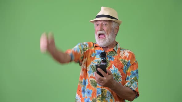 Handsome Senior Bearded Tourist Man Ready for Vacation Against Green Background