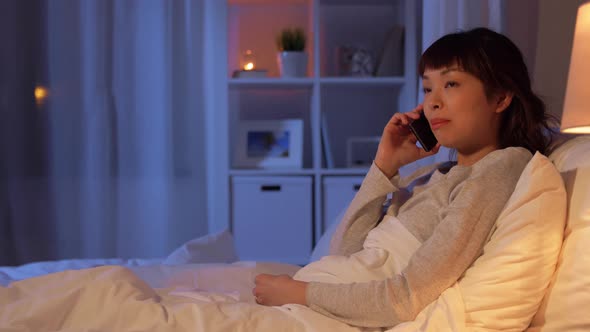Woman Calling on Smartphone in Bed at Night