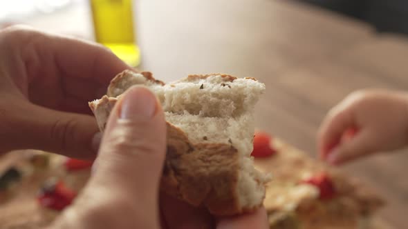 Close Up of Female Baker Braking Baguette Bread