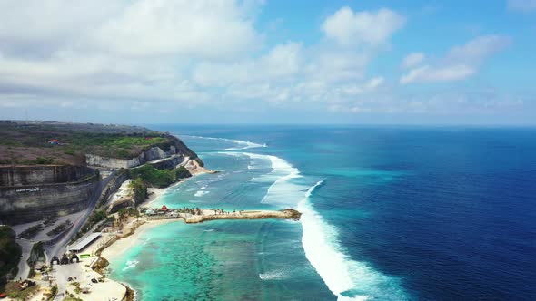 Beautiful Balinese coast with the cliffs and foamy waves washing on the fringing coral reef