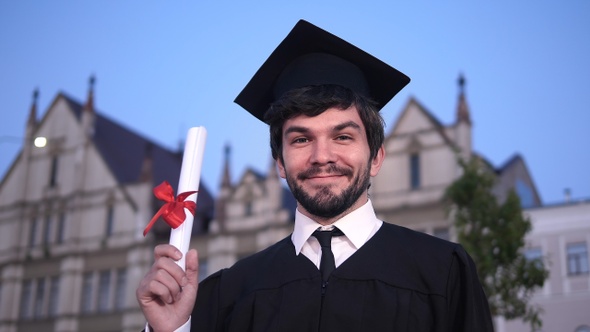 Caucasian happy young graduated man posing to the camera