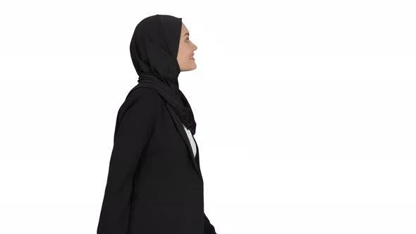 Smiling Islamic Female Model Wearing Hijab Walking and Looking Ahead on White Background