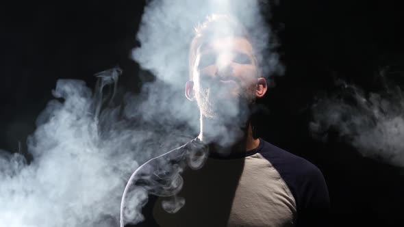Guy Smokes an Electronic Cigarette, Enjoy the Moment, Black Background