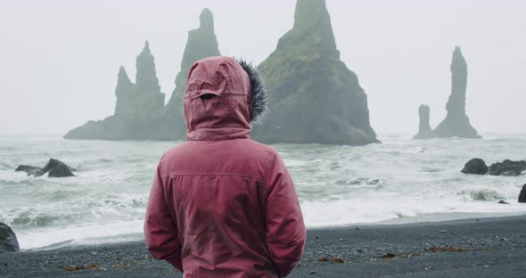 Woman Travel is Walking Along Reynisfjara Beach or Black Sand Beaches in Rain Weather Conditions