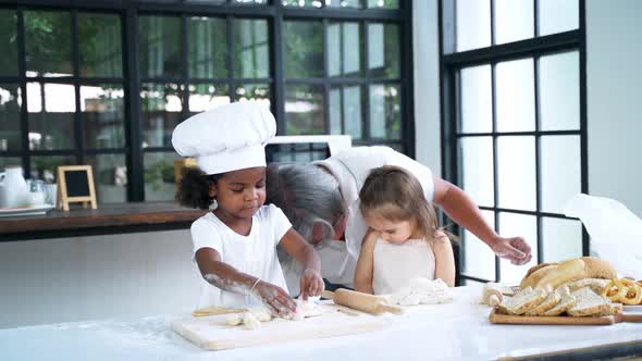 Young Adult Teaching Kids How to Bake in the Kitchen Room