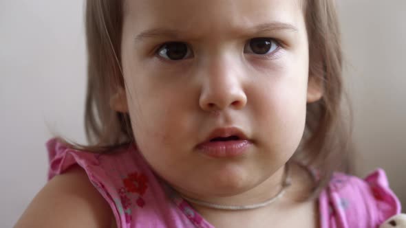 Small Toddler Girl Slavic Appearance Making Funny Expressive Grimace Face Sticks Out Tongue at Home