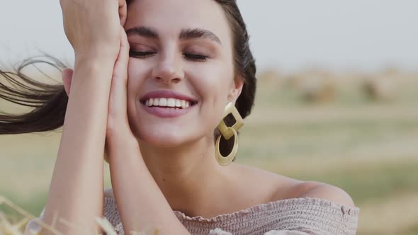 Portrait of Harmonized Calm Woman with Blowing Hair Looking and Smiling