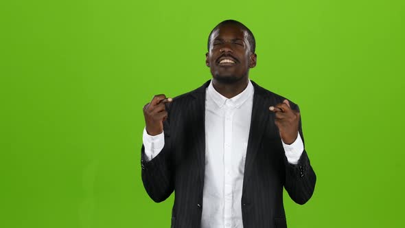 African American Crosses His Fingers, Hopes a Happy Occasion in His Endeavors. Green Screen