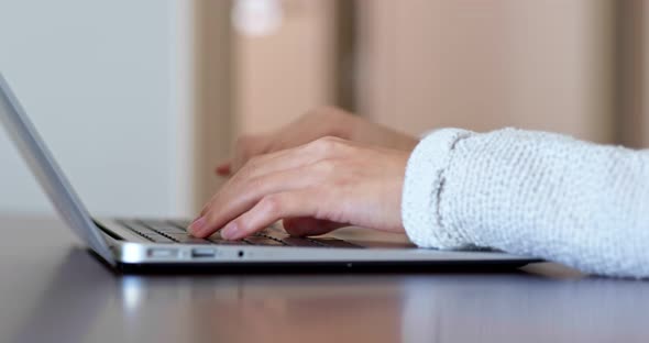 Woman type on keyboard of laptop computer at home