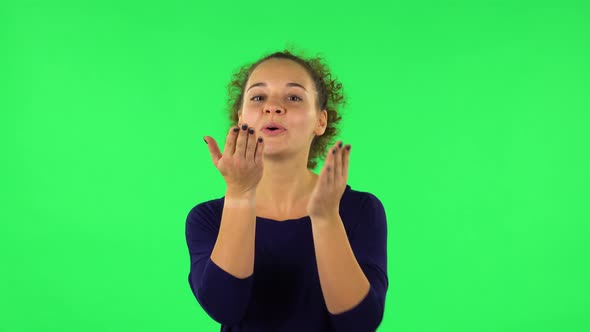 Portrait of Curly Woman Smiling and Blowing Kiss. Green Screen