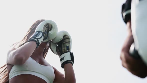 Boxing Training Outdoors  Young Woman in White Top Punching in the Mitts on Her Coaches Hand