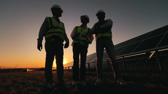 Safety Inspectors Are Arguing Next To Solar Batteries at Sundown