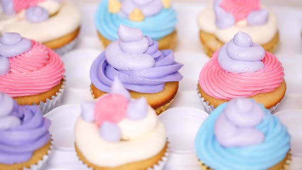 Step by step. Pastry chef piping butter cream frosting on unicorn cupcakes for little girl birthday 