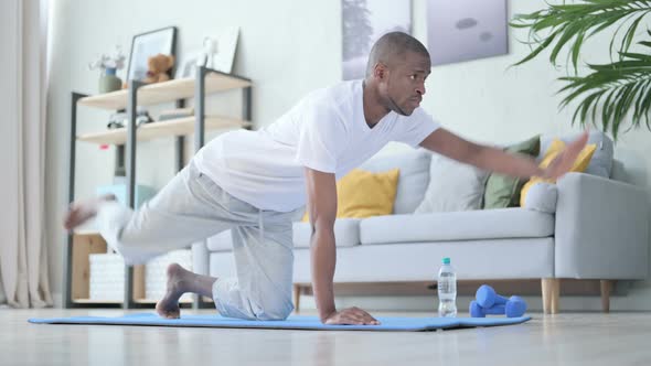 Young African Man Doing Workout on Yoga Mat at Home