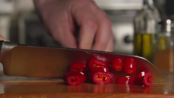 Cook Cuts A chili Pepper By A Knife