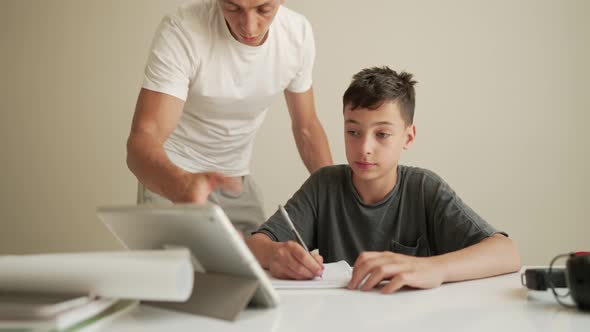 Father Helping Child Do His Homework at Home